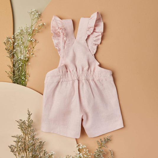 Detalle de costura y bolsillos de overoles rosados para niños