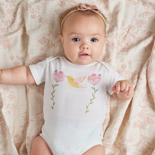 Body infantil con estampado de pájaros y ramitas en tonos suaves