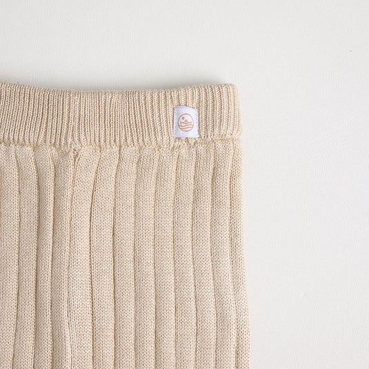 Vista lateral de pantalón acanalado en tono arena neutro