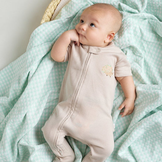 Pijama infantil con diseño de erizo en tonos tierra y verde menta
