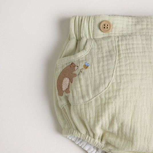Detalle de los broches de seguridad del cubrepañales con diseño de oso