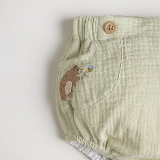 Detalle de los broches de seguridad del cubrepañales con diseño de oso