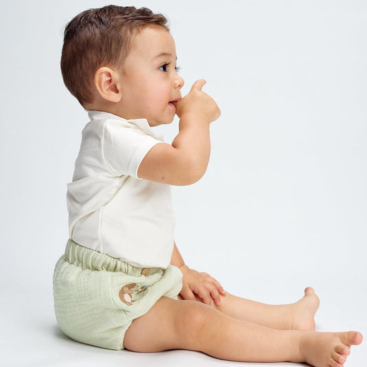 Vista frontal de cubrepañales de oso con detalle de nariz bordada