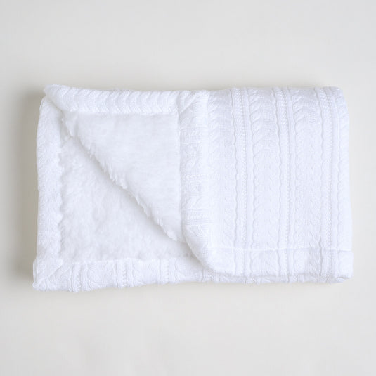 Vista completa de la manta ovejera blanca desplegada sobre superficie neutra