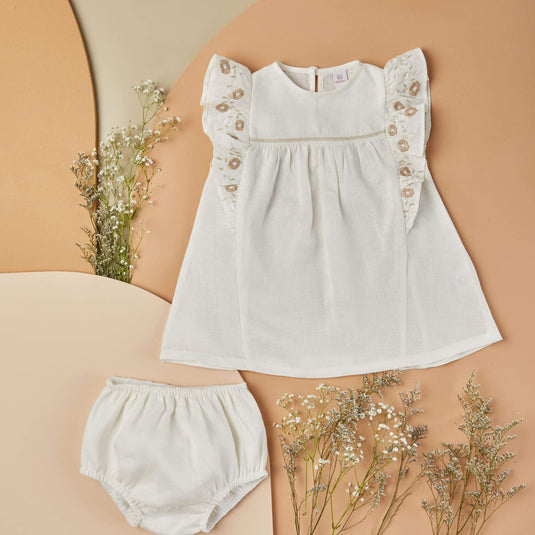 Conjunto beige para niña con vestido corto y calzón a juego, tejido de punto.