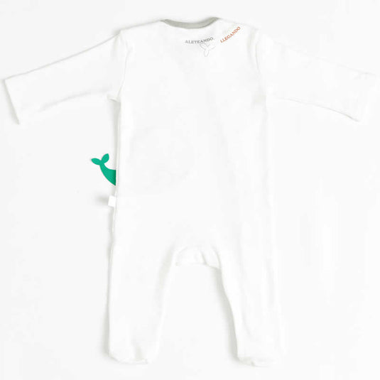 Niño sonriente modelando pijama azul con ballenas