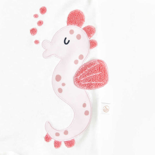 Vista frontal de pijama infantil 3D con caballito de mar y detalles en relieve.