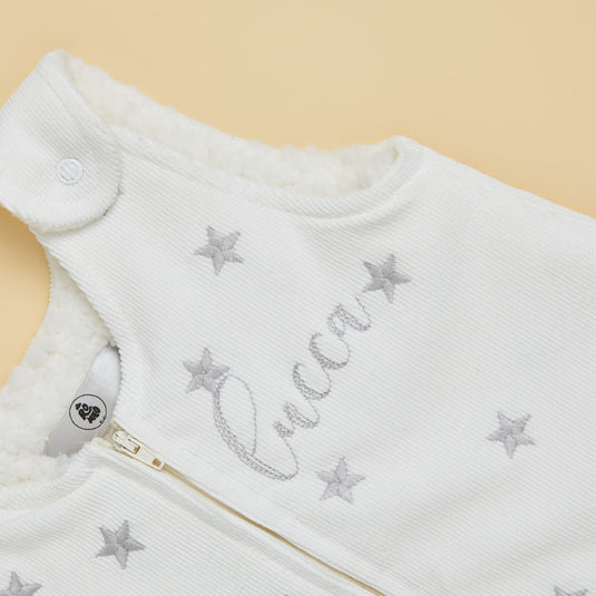 Vista frontal de saco de dormir infantil con cremallera y estrellas brillantes.