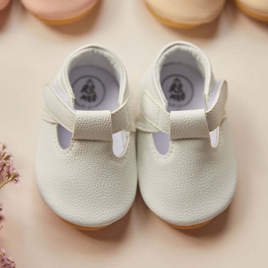 Zapatitos blancos para bebé recién nacido con detalles en puntilla