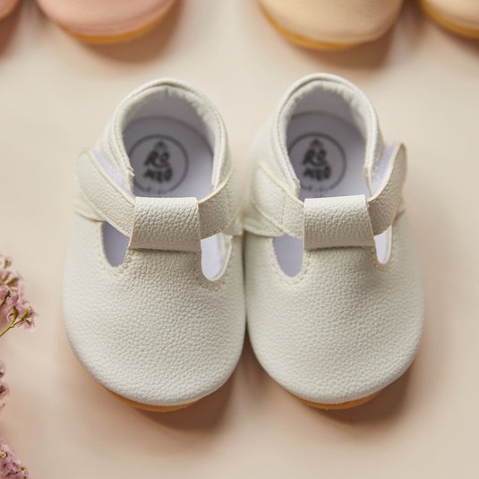 Zapatitos blancos para bebé recién nacido con detalles en puntilla