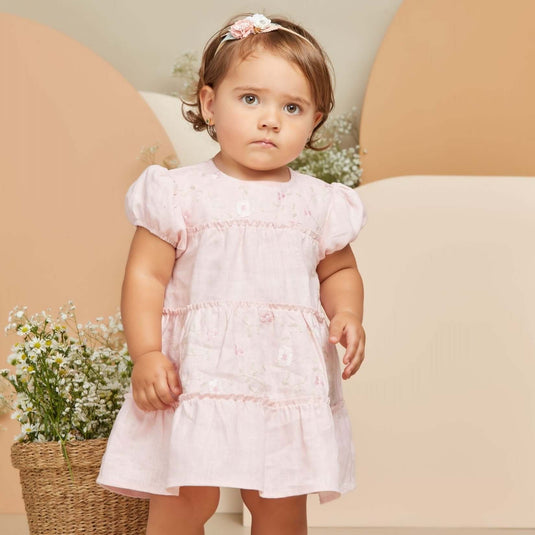 Conjunto infantil de dos piezas en tono beige con bordados delicados.