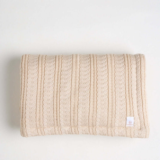Manta ovejera en tono arena con tejido suave y diseño de relieve